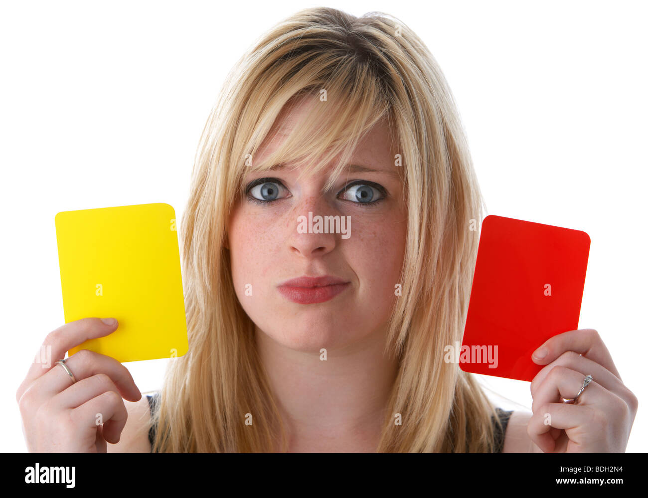 junge 20 jährige blonde Frau mit roten und gelben Fußball Fußball Warnung Karten mit verwirrten Blick auf ihrem Gesicht Stockfoto