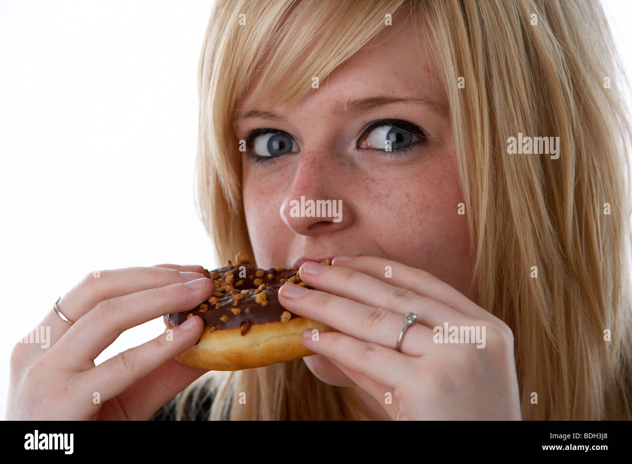 junge 20 jährige blonde Frau essen große Schokolade donut Stockfoto