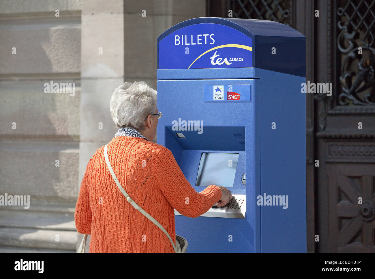 Ältere Frau an einem Ticket-Automaten, Straßburg, Frankreich Stockfoto