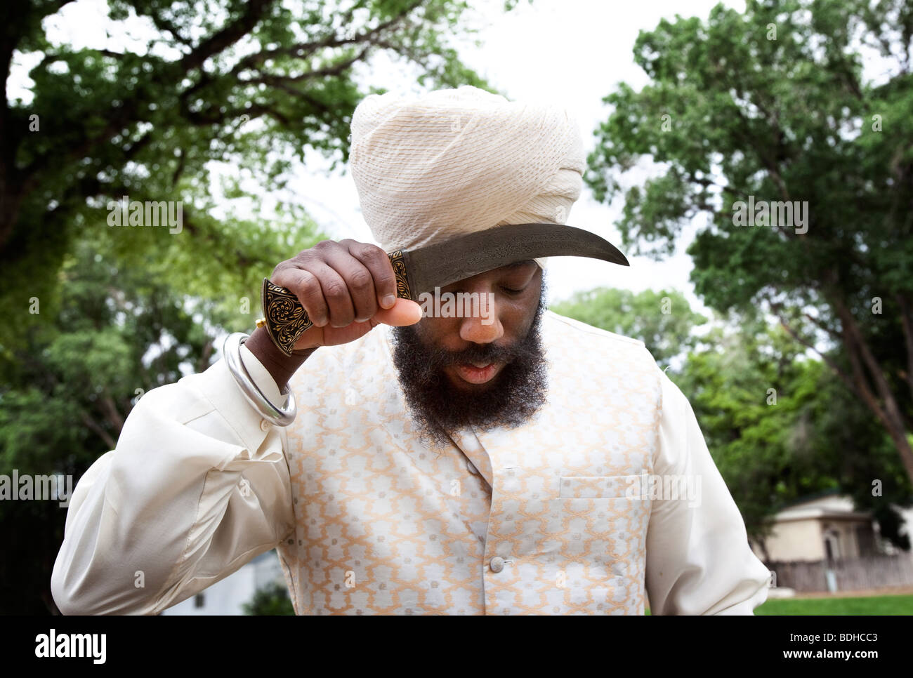 Ein Sikh Mann berührt die Kirpan (Heiliger Dolch) an die Stirn zu respektieren. Stockfoto