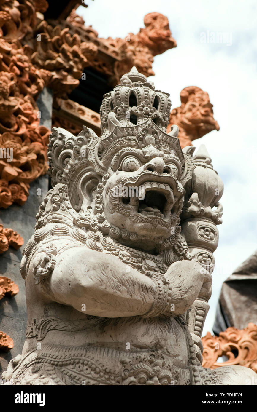 Indonesien, Bali, Kuta, Jalan Pantai, geschnitzten Stein Hindu-Gottheit vor kleinen lokalen Tempel Stockfoto