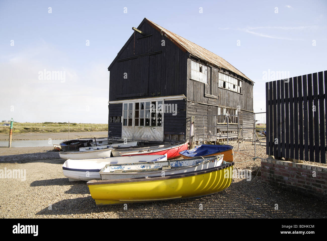 Gestrandeter Handwerk auf der shore.boatyard in niedrigen tide.marshes,sheds&wooden Boote Stockfoto