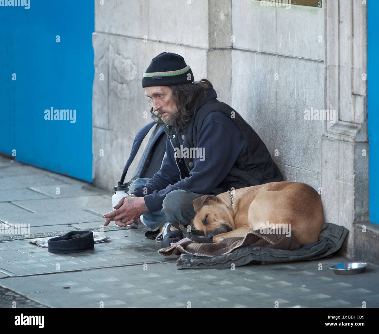 Ein Obdachloser Mann betteln mit seinem Hund, London, England Stockfoto