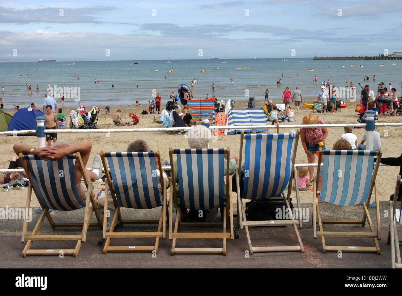Urlauber genießen den Blick auf Strand von Weymouth aus ihren Liegestühlen Stockfoto