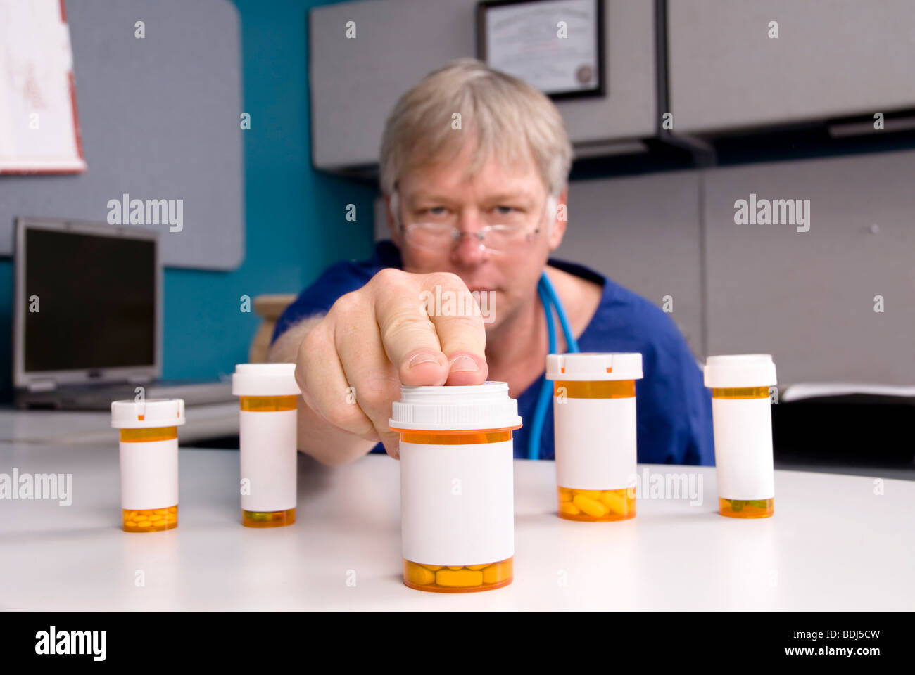 Ein Arzt wählt ein Medikament für seine Kunden. Etiketten sind leere Kopie auf die Pille Flaschen ermöglichen. Stockfoto