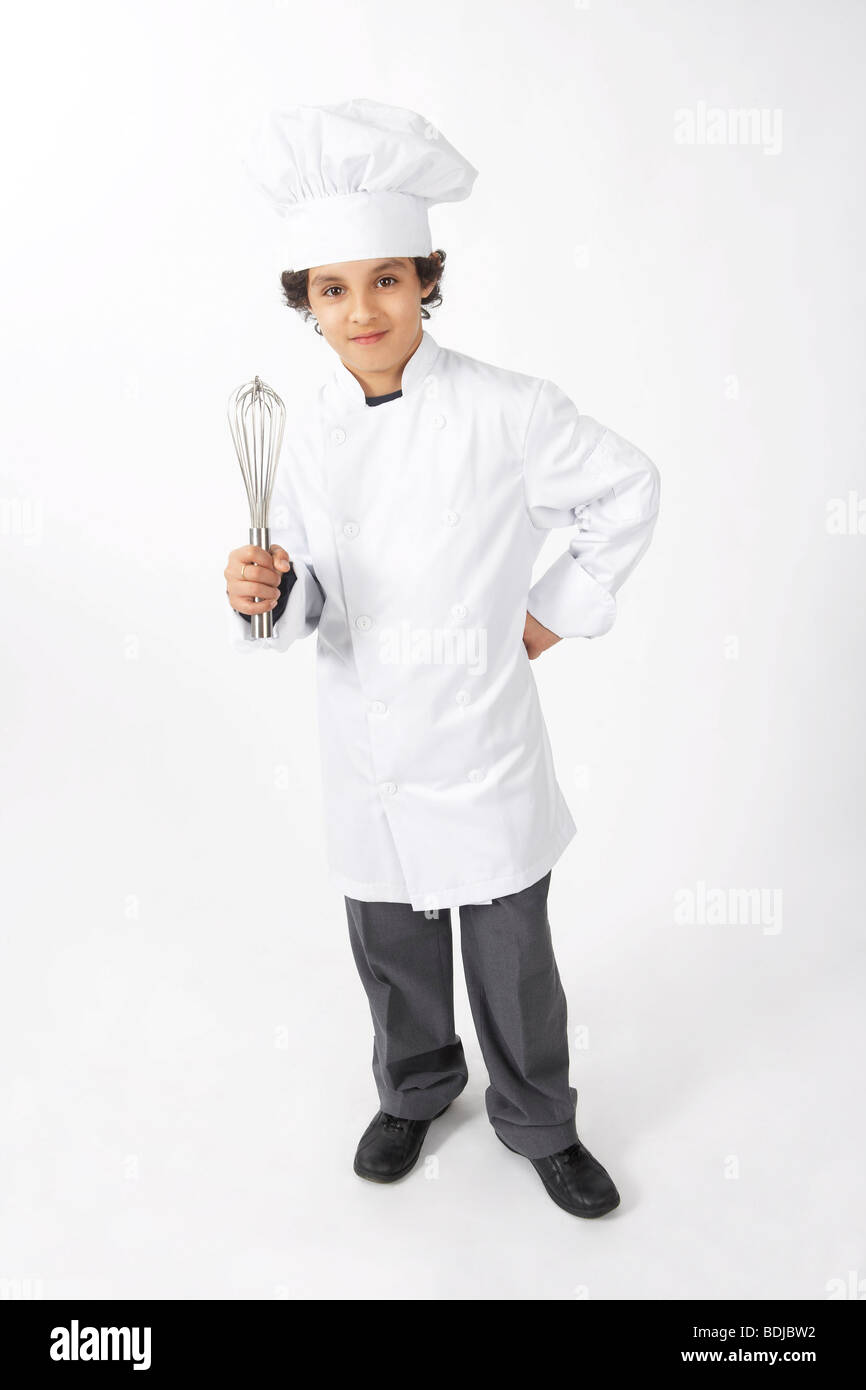 Junge verkleidet als Koch mit einem Schneebesen Stockfoto