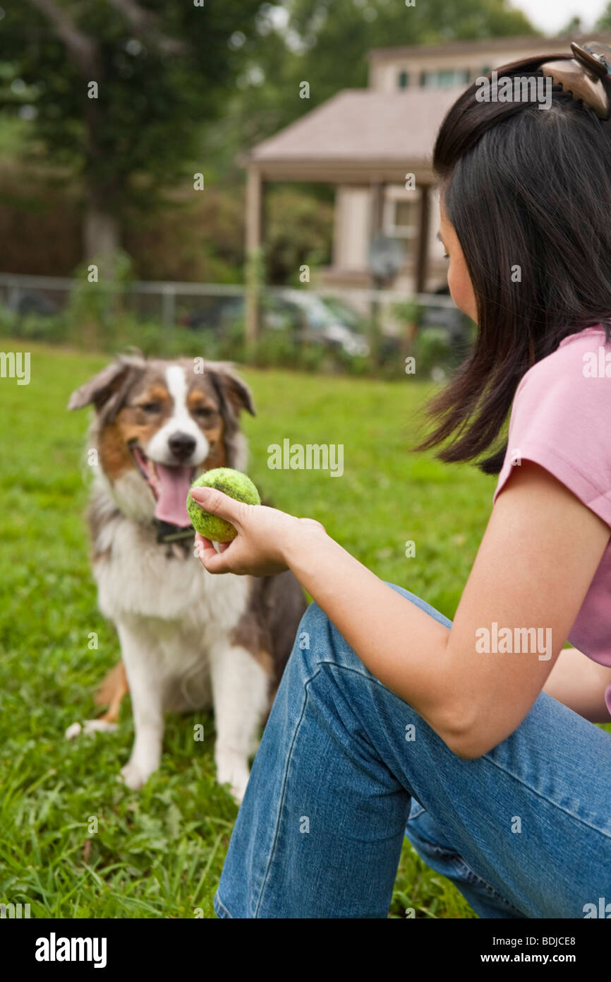Frau spielt fangen mit Hund Stockfoto