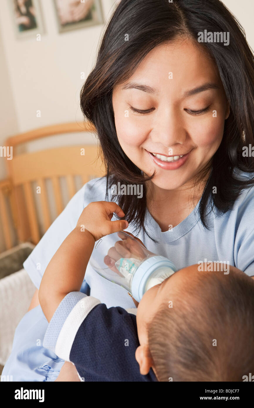 Mutter hält Baby Boy während er trinken von Baby-Flasche ist Stockfoto