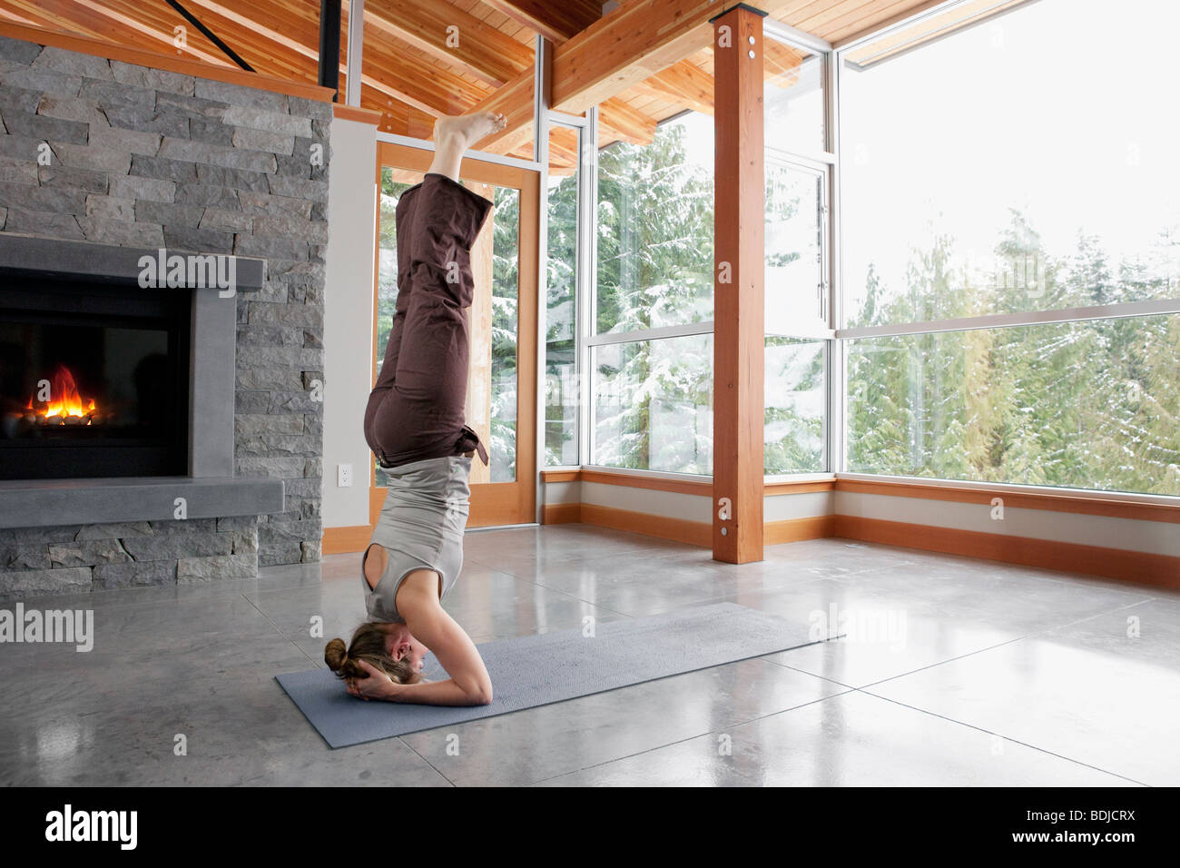 Frau beim Yoga im Wohnzimmer großen alpinen Hauses Stockfoto