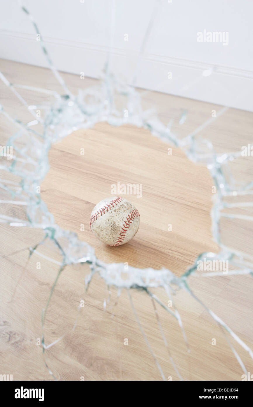 Baseball und zerbrochenes Fenster Stockfoto