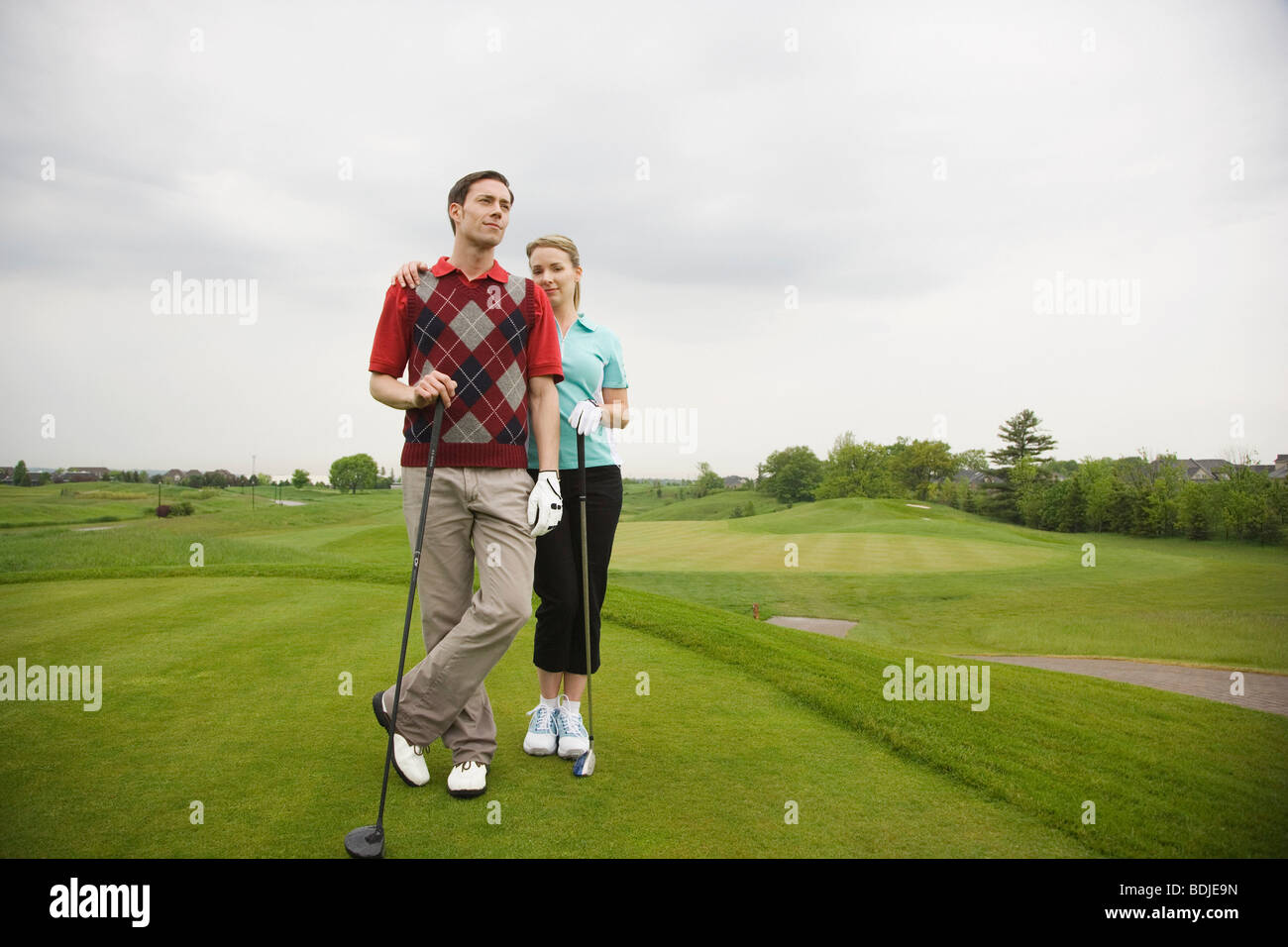 Porträt des Paares stehen auf Golfplatz Stockfoto