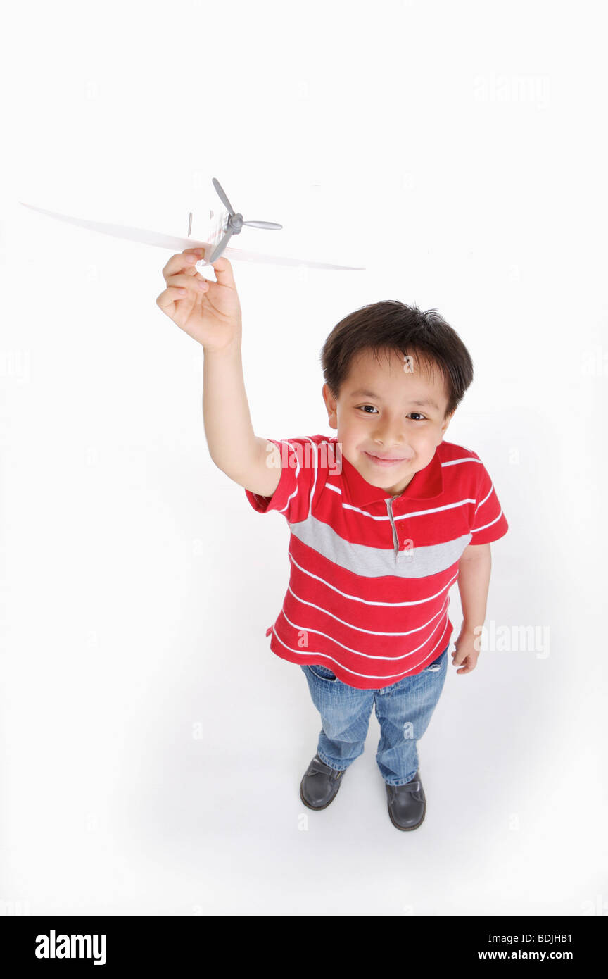Junge hält ein Flugzeug und nachschlagen, Kind Stockfoto