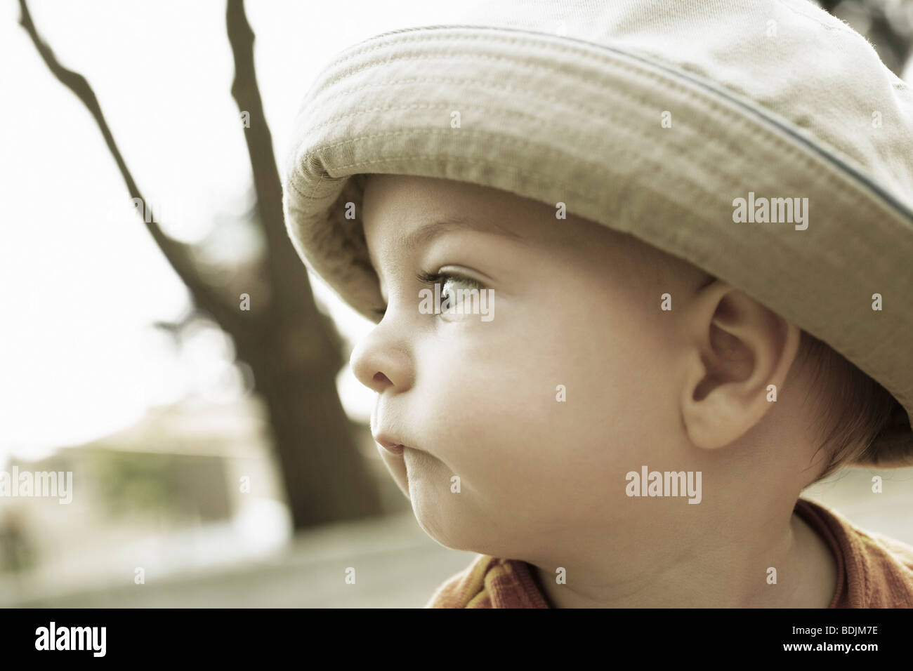Kleiner Junge mit Hut seine Unterlippe beißen Stockfoto