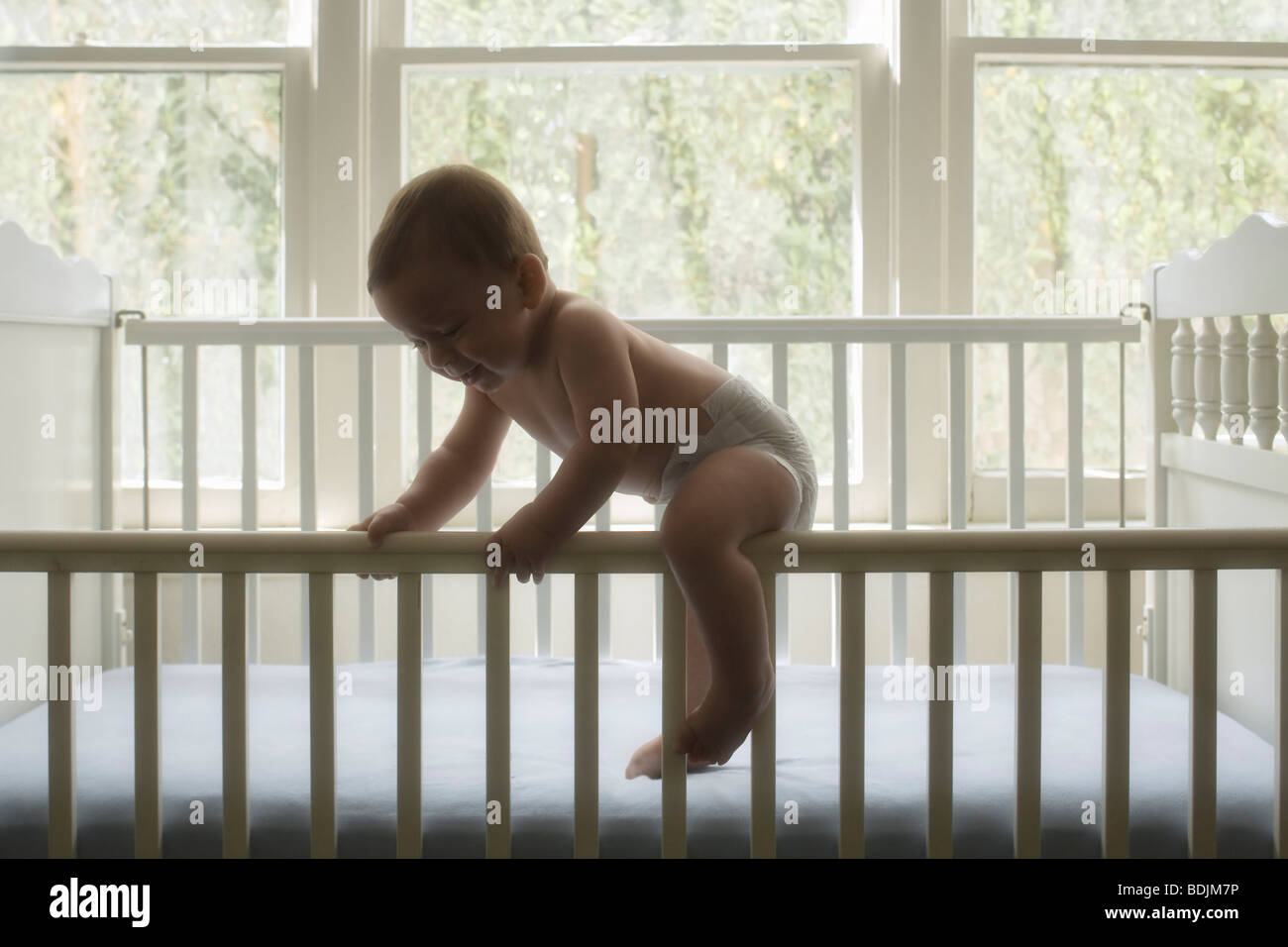 Baby Boy klettern aus der Krippe Stockfoto