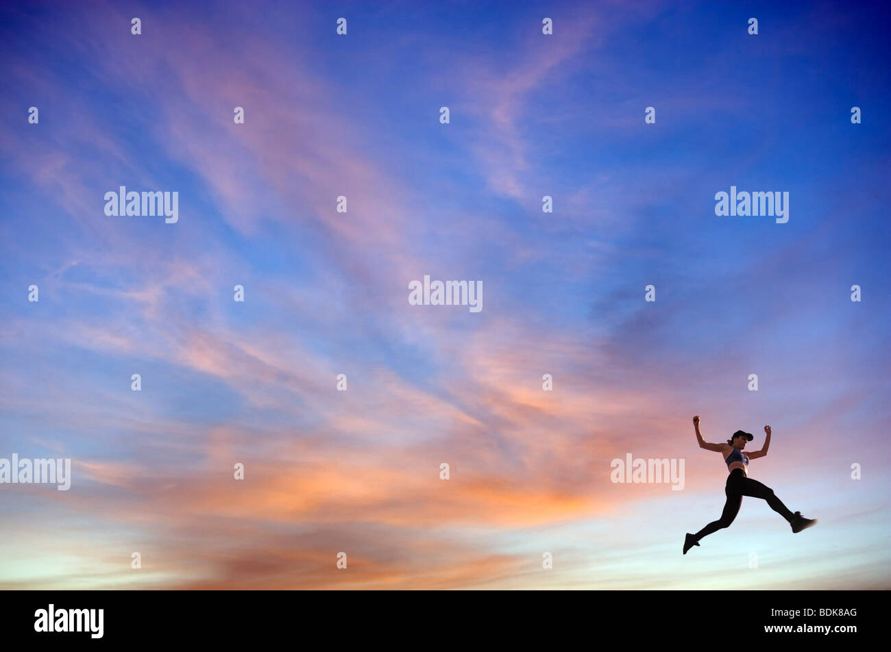 Frau Wanderer springen bei Sonnenuntergang Stockfoto