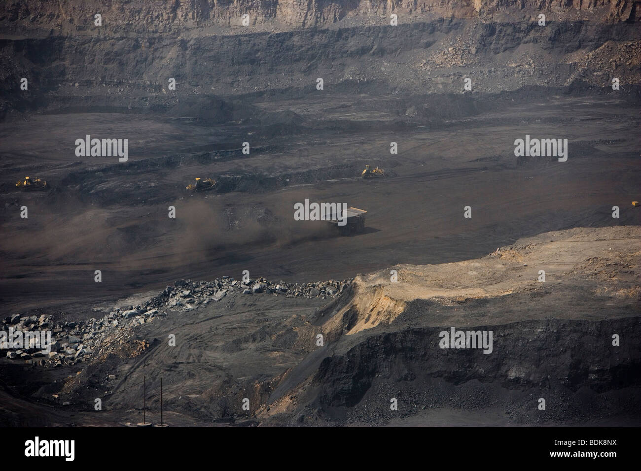 EIN TAI BAO MINE, Provinz SHANXI, CHINA - AUGUST 2007: LKW werfen Staub wie sie Kohle aus dieser riesigen Tagebau-Mine sammeln Stockfoto