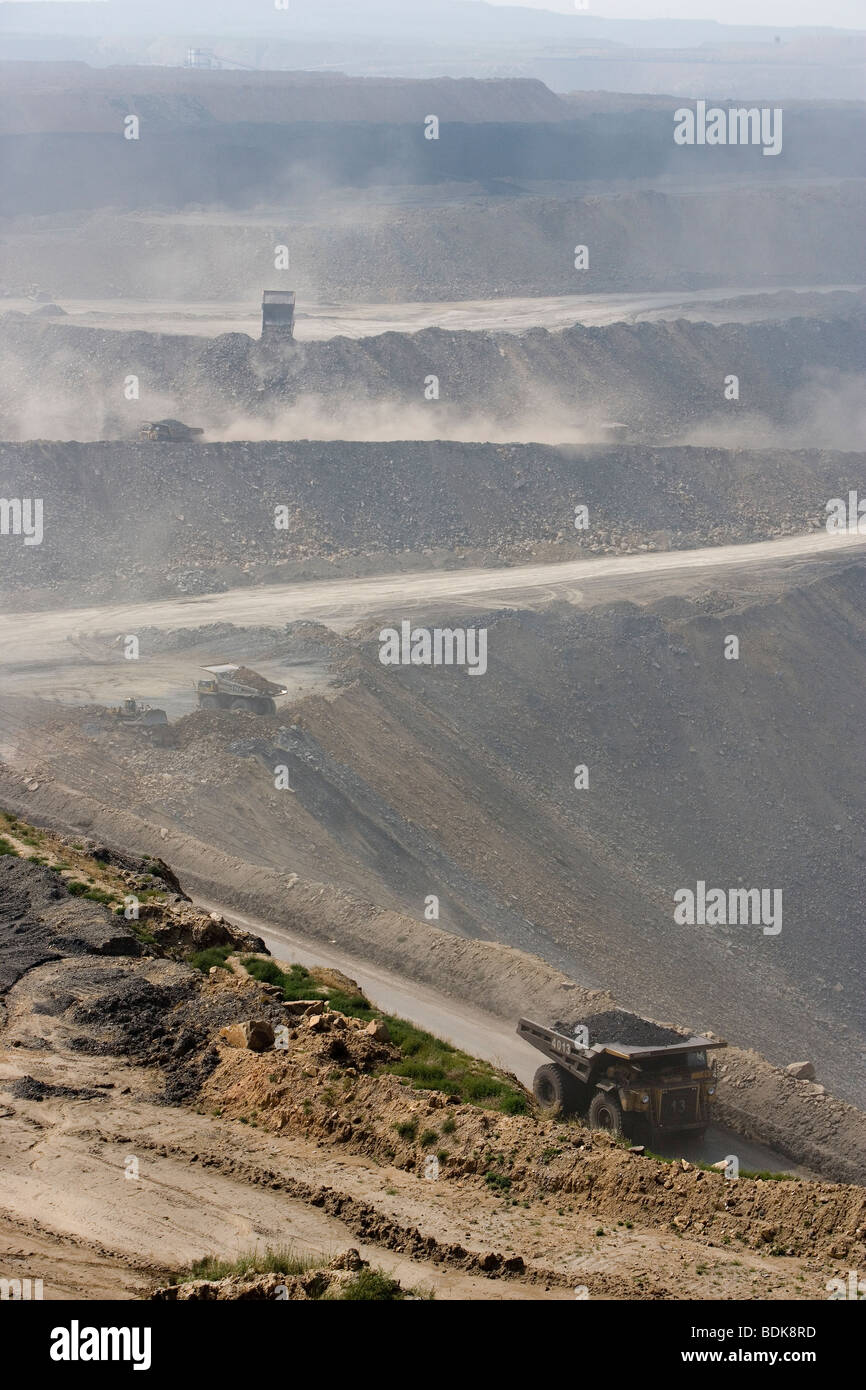 EIN TAI BAO MINE, Provinz SHANXI, CHINA - AUGUST 2007: LKW werfen Staub wie sie Kohle aus dieser riesigen Tagebau-Mine sammeln Stockfoto