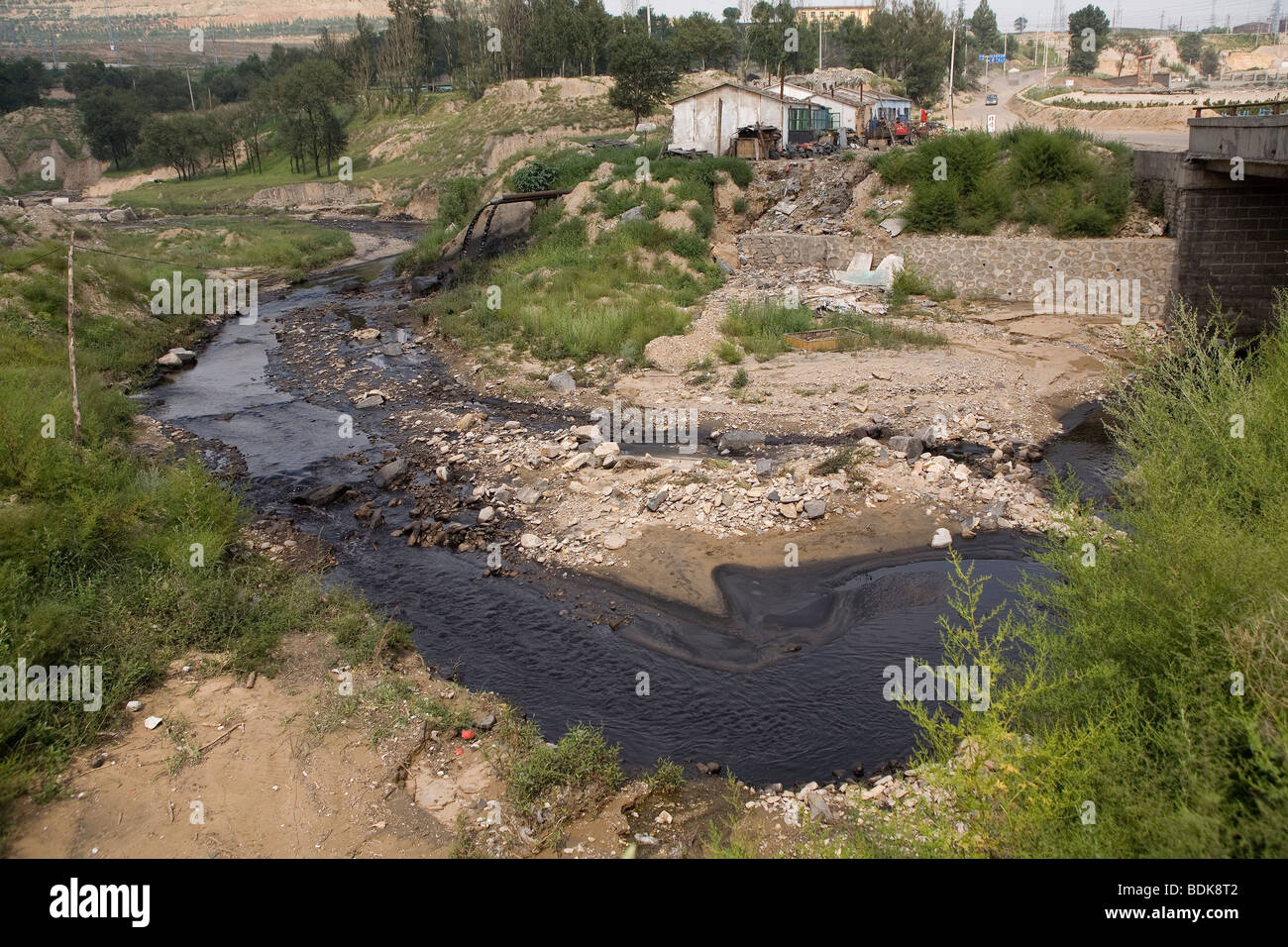EIN TAI BAO MINE, Provinz SHANXI, CHINA - AUGUST 2007: Der Stream vorbei an den riesigen ist offen-Kaste mir schwarz mit Verschmutzung Stockfoto