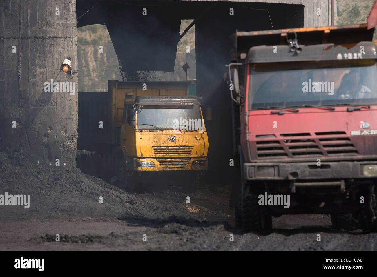 EIN TAI BAO MINE, Provinz SHANXI, CHINA - AUGUST 2007: Straßentauglichen LKW füllen sich mit Kohle aus einem obenliegenden Trichter. Stockfoto