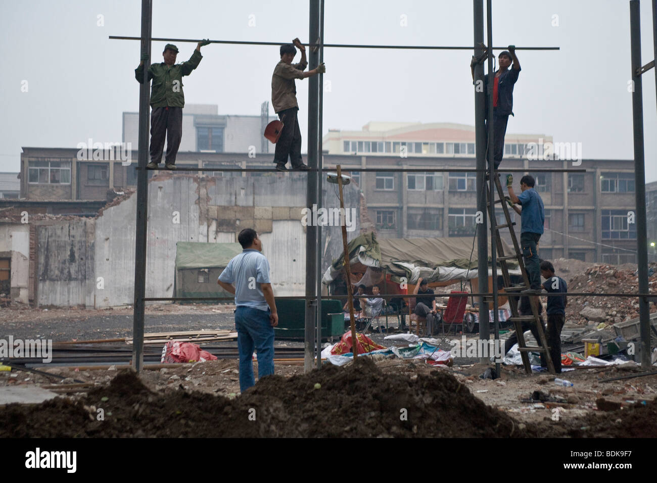 TAIYUAN, Provinz SHANXI, CHINA - August 2007: Bauarbeiter montieren Stahl Werbung Horten Struktur. Stockfoto