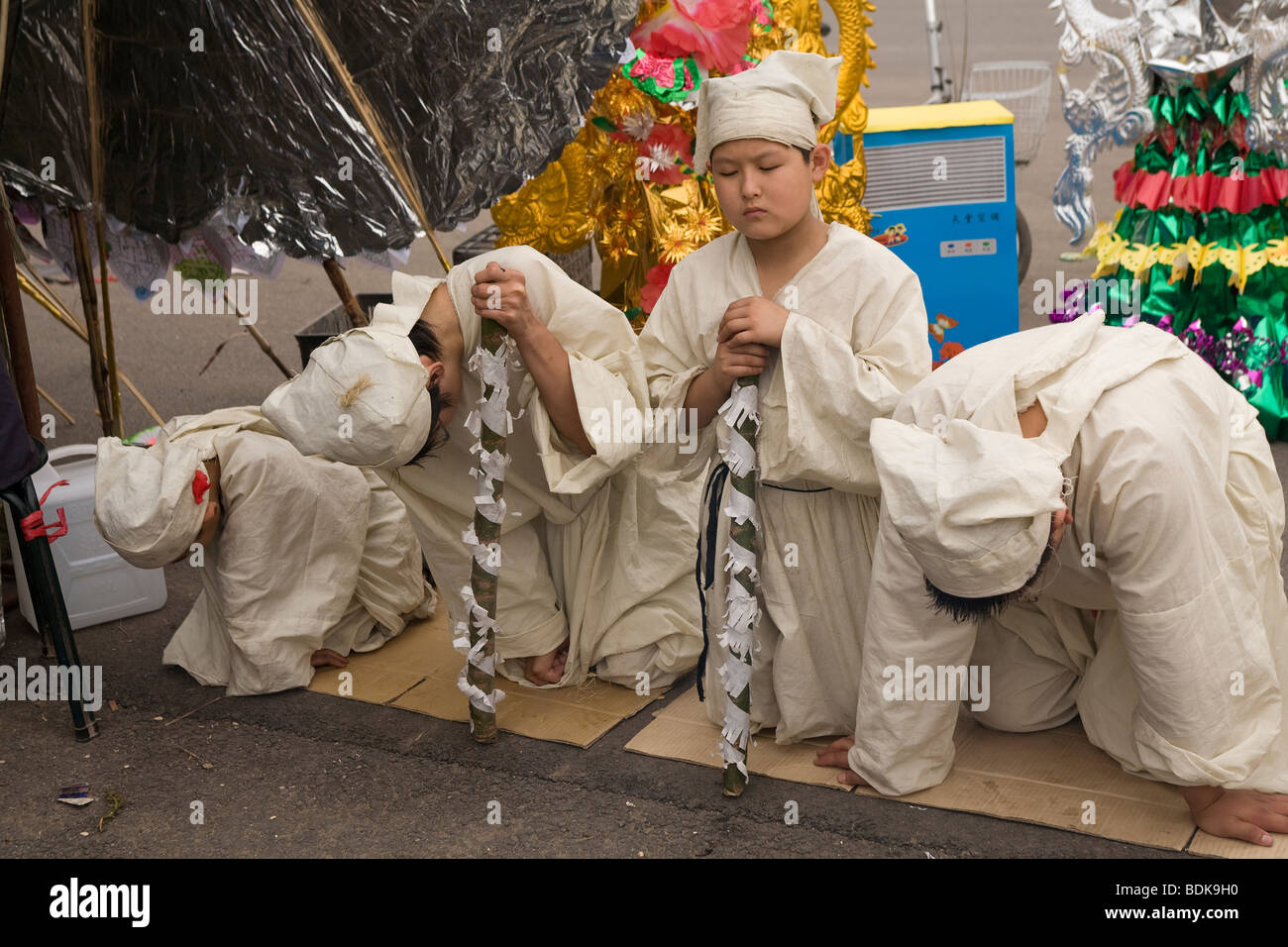 TAIYUAN, Provinz SHANXI, CHINA - August 2007: Jungen gekleidet in weißen Zahlen ihren Respekt an einen Trauerzug Stockfoto