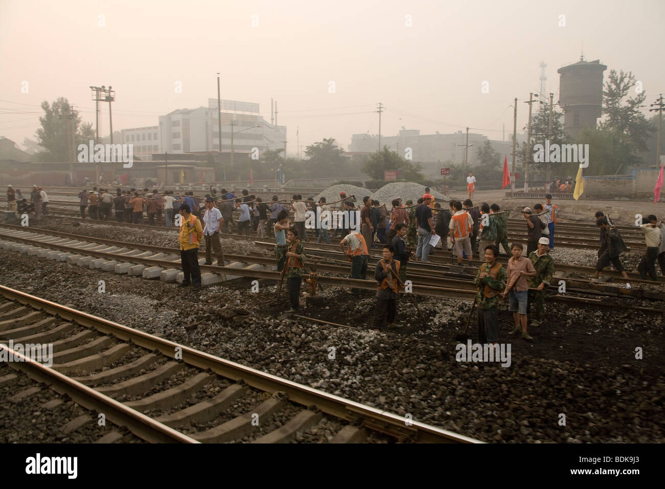 JIEXIU, Provinz SHANXI, CHINA - AUGUST 2007: ein Team von Eisenbahnern arbeiten paarweise verwenden Joche, um eine Stahlschiene zu heben. Stockfoto