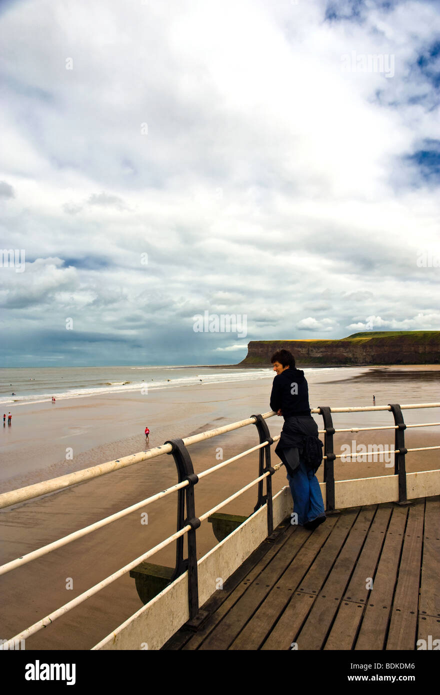 Frau stand am Pier beobachten Surfer Stockfoto