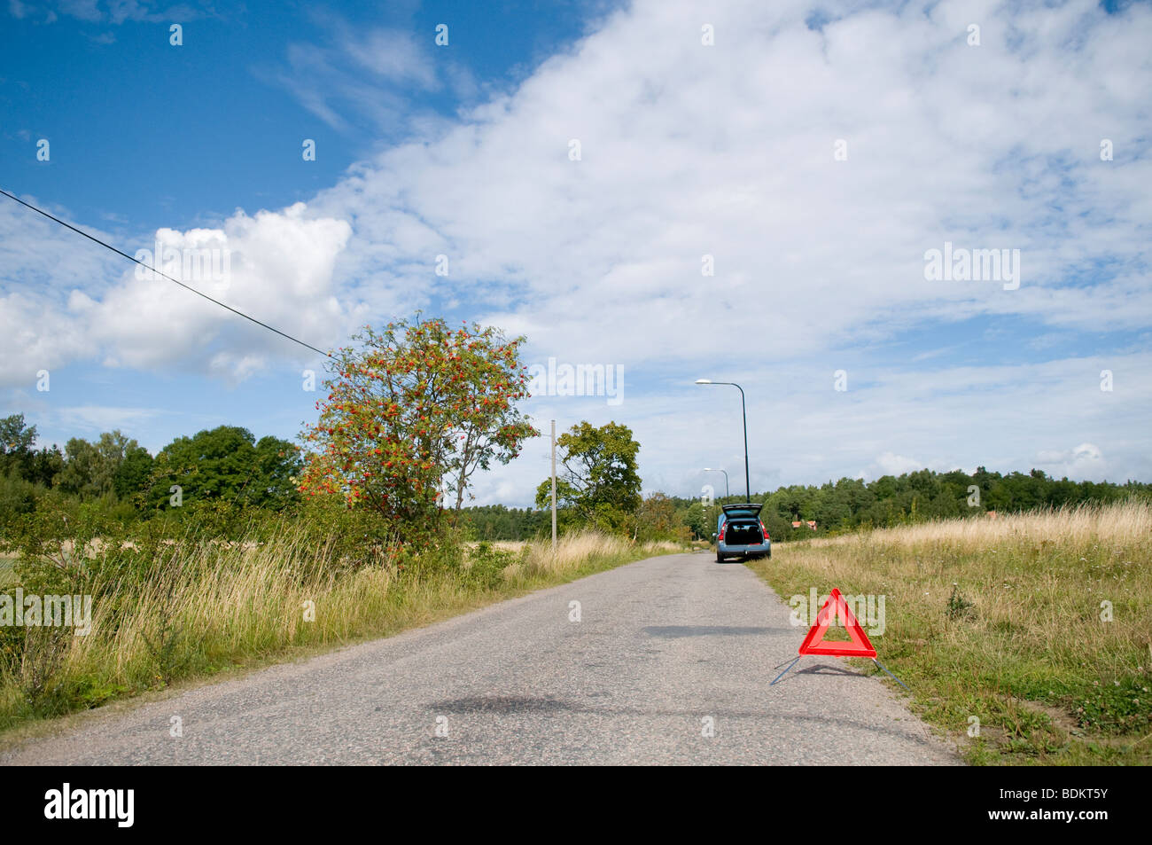 Kaputtes Auto durch eine Landstraße. Warndreieck nach vorne. Stockfoto