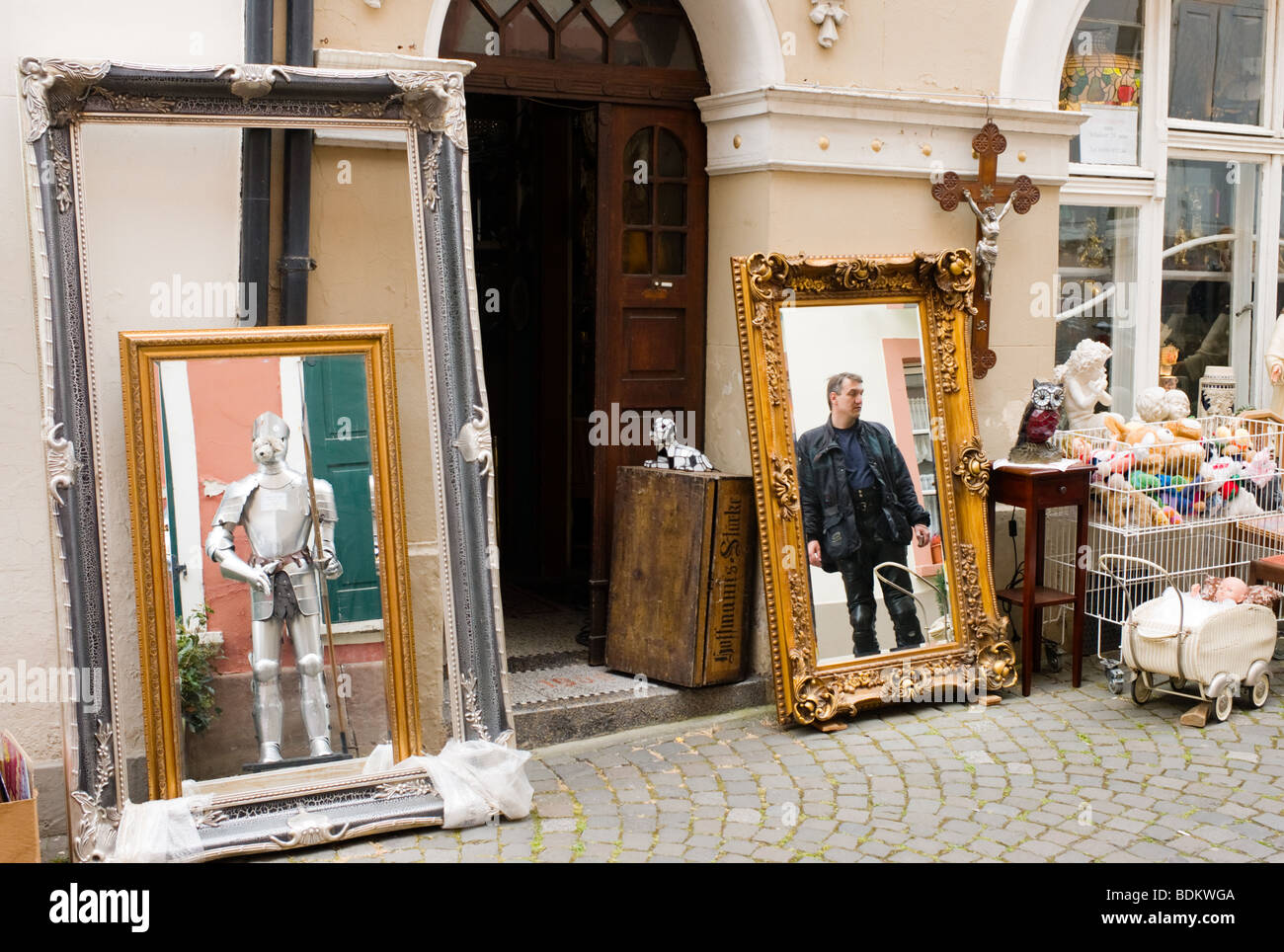 Ein Mann und eine Klage der Rüstung spiegeln sich in zwei Spiegel in der deutschen Stadt von Bernkastel-Kues an der Mosel Stockfoto