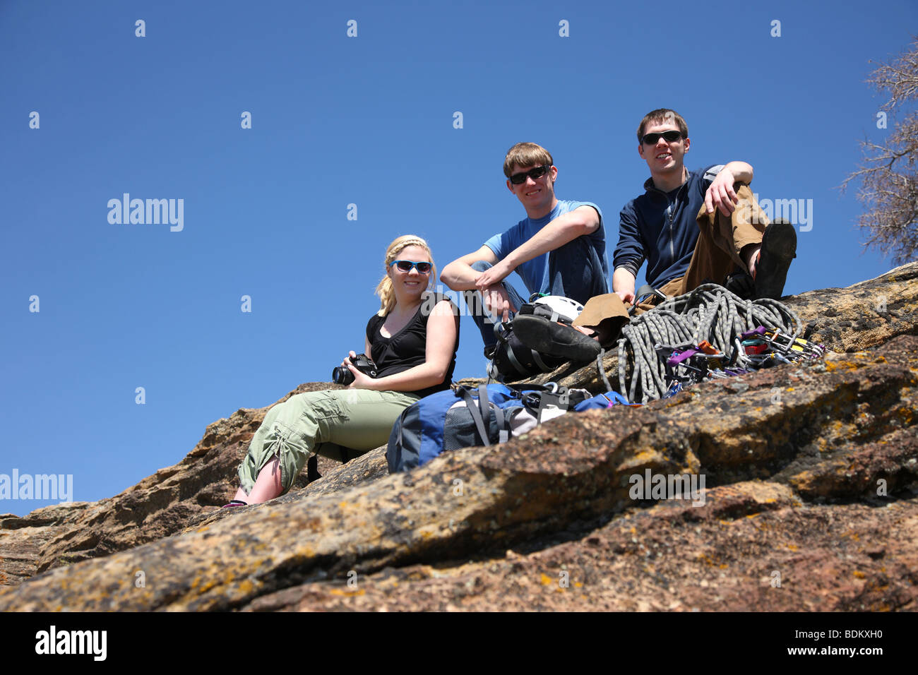 Drei junge Erwachsene Zusammensitzen auf Felsen Stockfoto