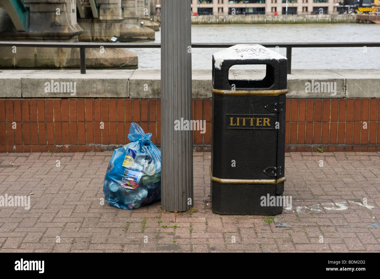 Leere Abfallbehälter und Kunststoff Abfallsack voller Abfälle deponiert auf der Böschung London, UK Stockfoto
