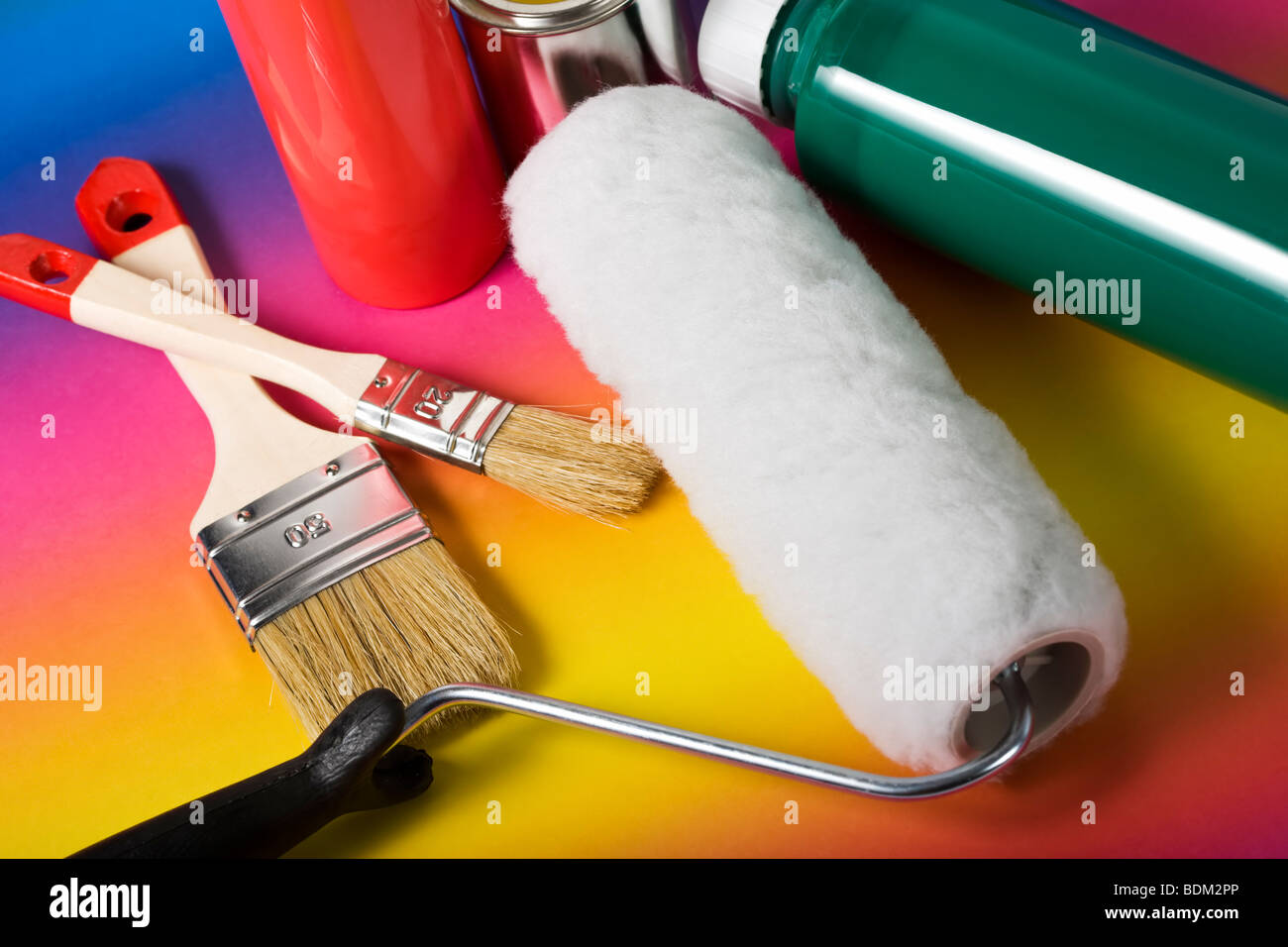 Vielzahl von Lackieranlagen - Pinsel, Farbroller, Farbe, Lack kann - auf Regenbogen farbig hinterlegt Stockfoto