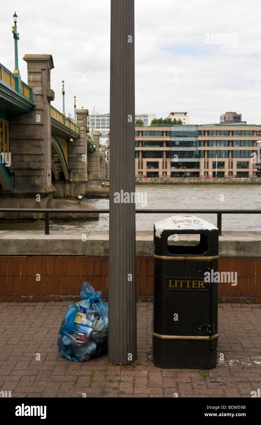 Leere Abfallbehälter und Kunststoff Abfallsack voller Abfälle deponiert auf der Böschung London, UK Stockfoto
