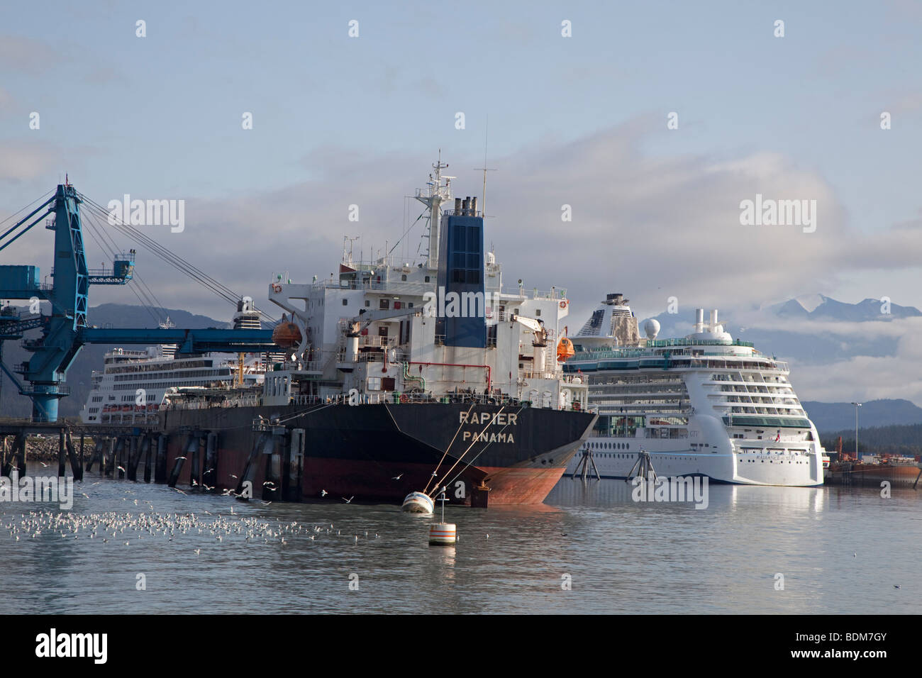 Seward, Alaska - das Schiff braucht Rapier auf eine Last von Kohle umgeben von Kreuzfahrtschiffen im Hafen von Seward. Stockfoto