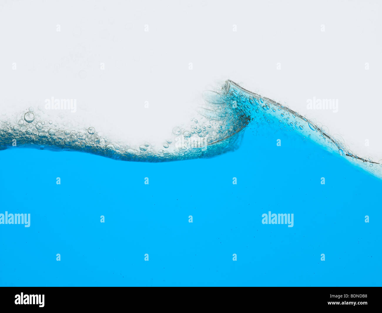 Welle der blauen Flüssigkeit vor weißem Hintergrund Oberflächenansicht Stockfoto