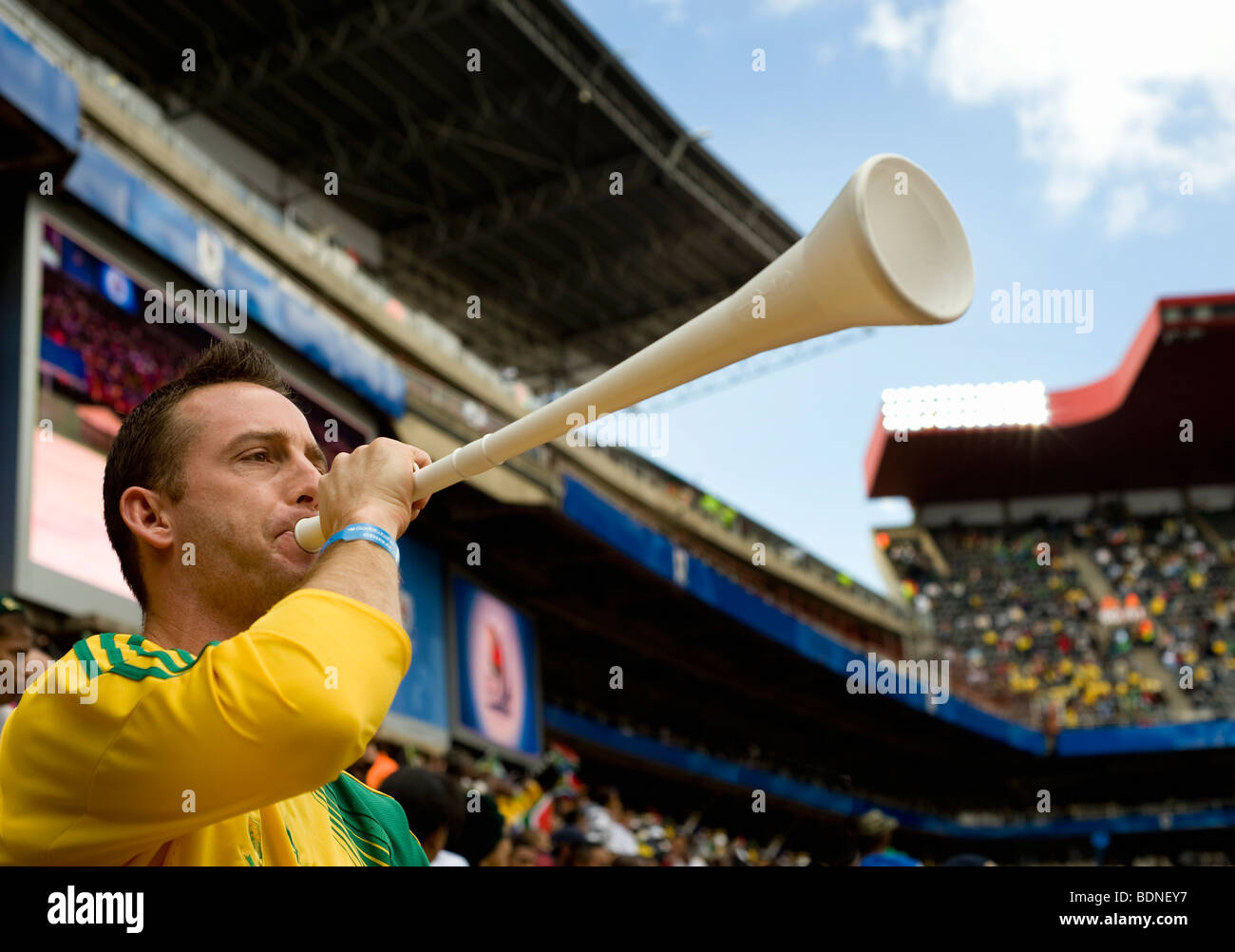 Mann bläst eine Vuvuzela in einem Fußballstadion, Johannesburg, Südafrika Stockfoto