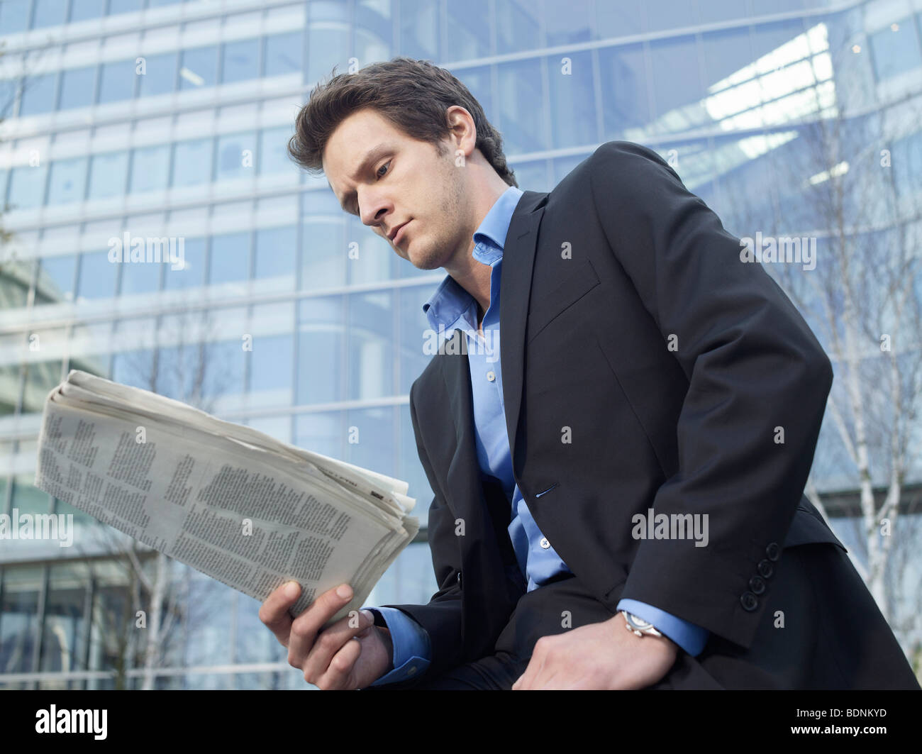 Mittleren Erwachsenenalter Geschäftsmann Zeitunglesen vor Bürogebäude Stockfoto