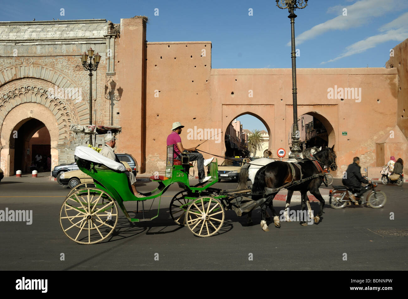 Bab Agnaou City Gate in den Stadtmauern mit Touristen Sightseeing in einem Pferd & Kutsche, Caleche, Barouche oder Hackney Cab, Marrakesch, Marokko Stockfoto