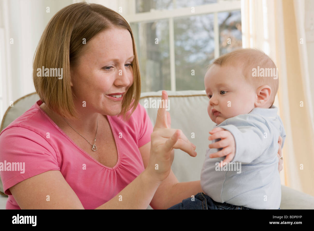 Frau, die Unterzeichnung des Satzes "Ich liebe dich" in amerikanischer Gebärdensprache während der Kommunikation mit ihrem Sohn Stockfoto