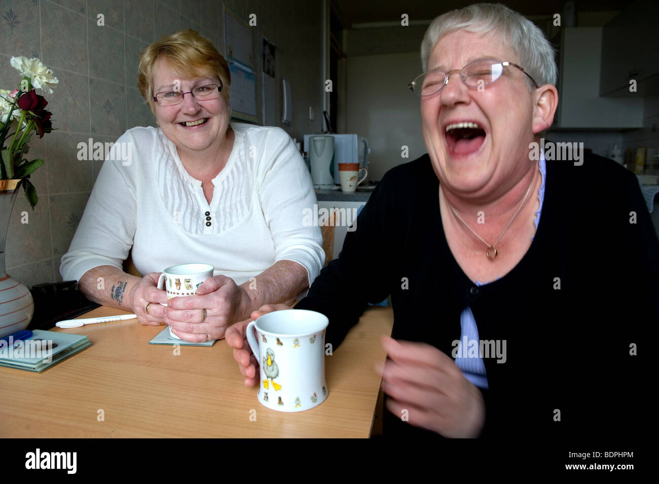 Zwei ältere Frauen teilen einen Witz bei einer Tasse Tee. Stockfoto