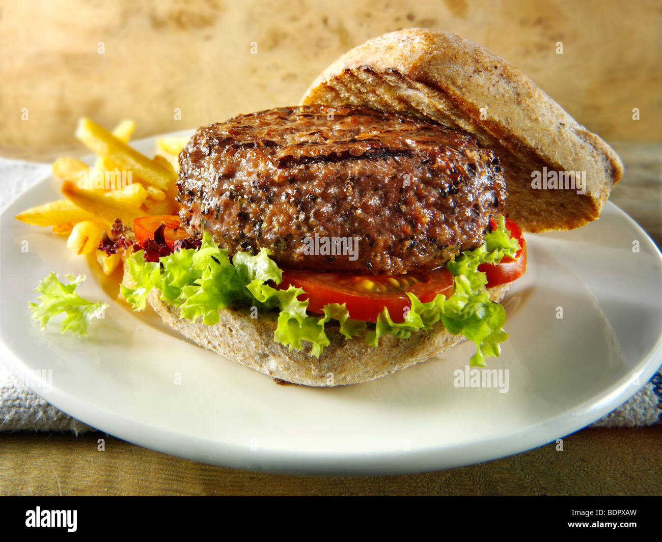 Gepfefferter Beef-Burger mit Pommes Frites und Vollkorn Brötchen Stockfoto