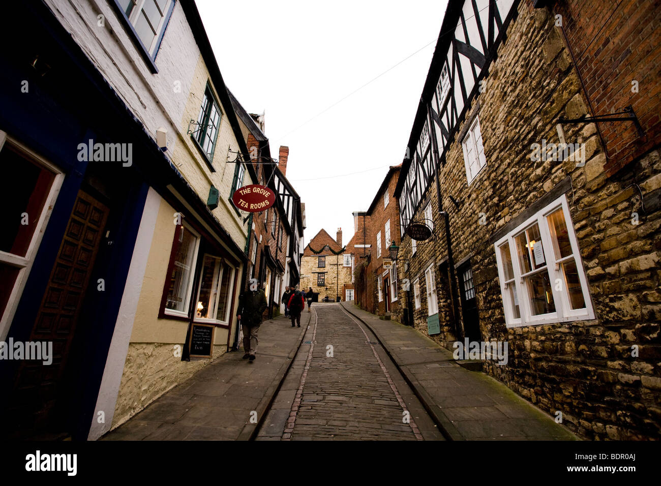 Eine enge Kopfsteinpflasterstraße gesäumt von historischen Gebäuden im Cathedral Quarter von Lincoln, England. Stockfoto