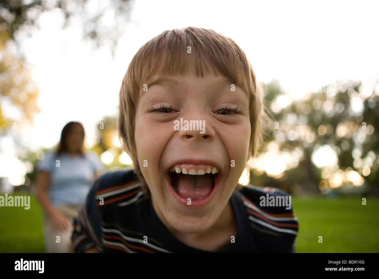sechs Jahre alter Junge hysterisch lachend in die Kamera Stockfoto