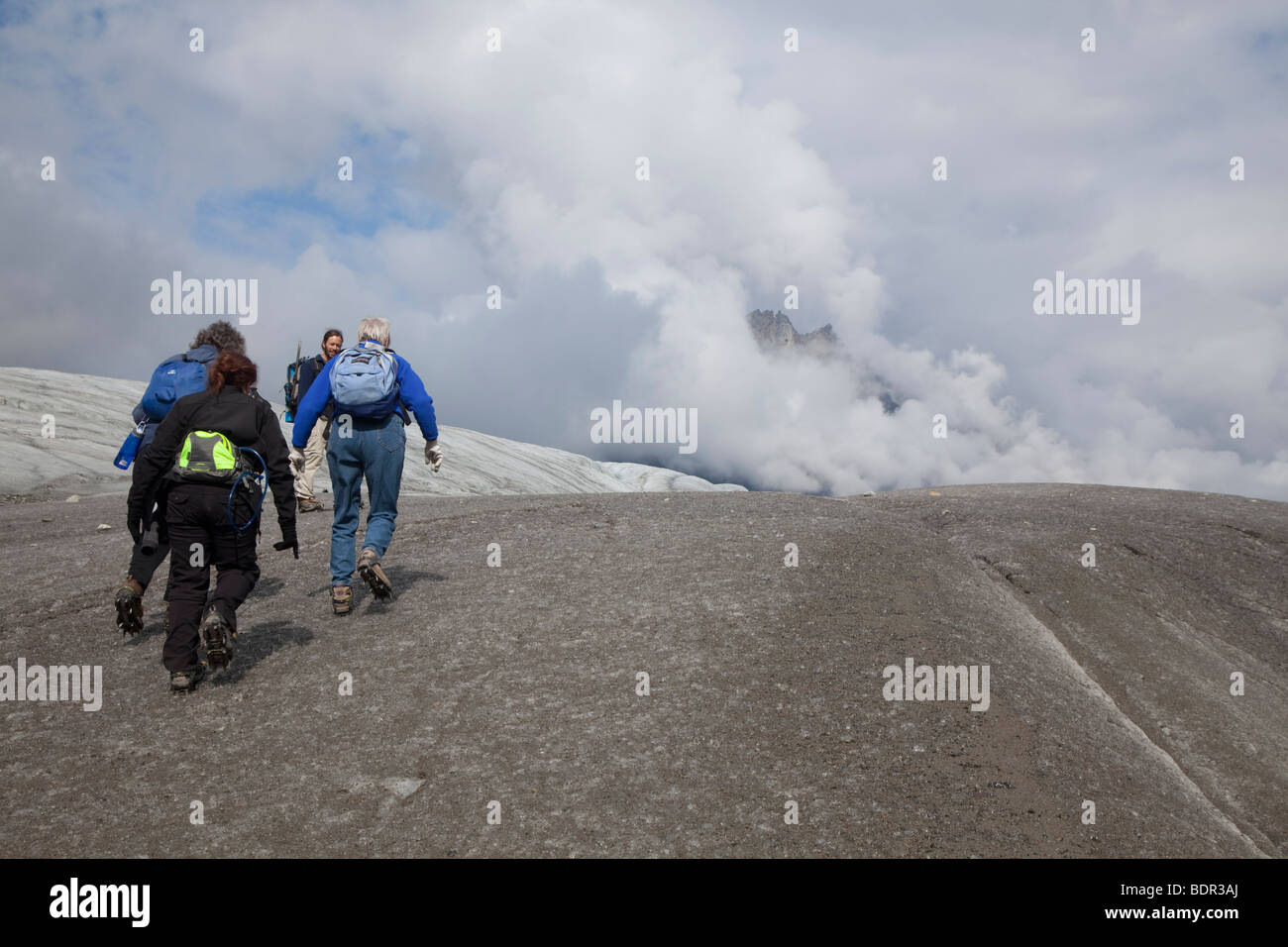 Kennicott, Alaska - ein Leitfaden führt drei Frauen auf dem Root-Gletscher im Wrangell-St.-Elias-Nationalpark wandern. Stockfoto