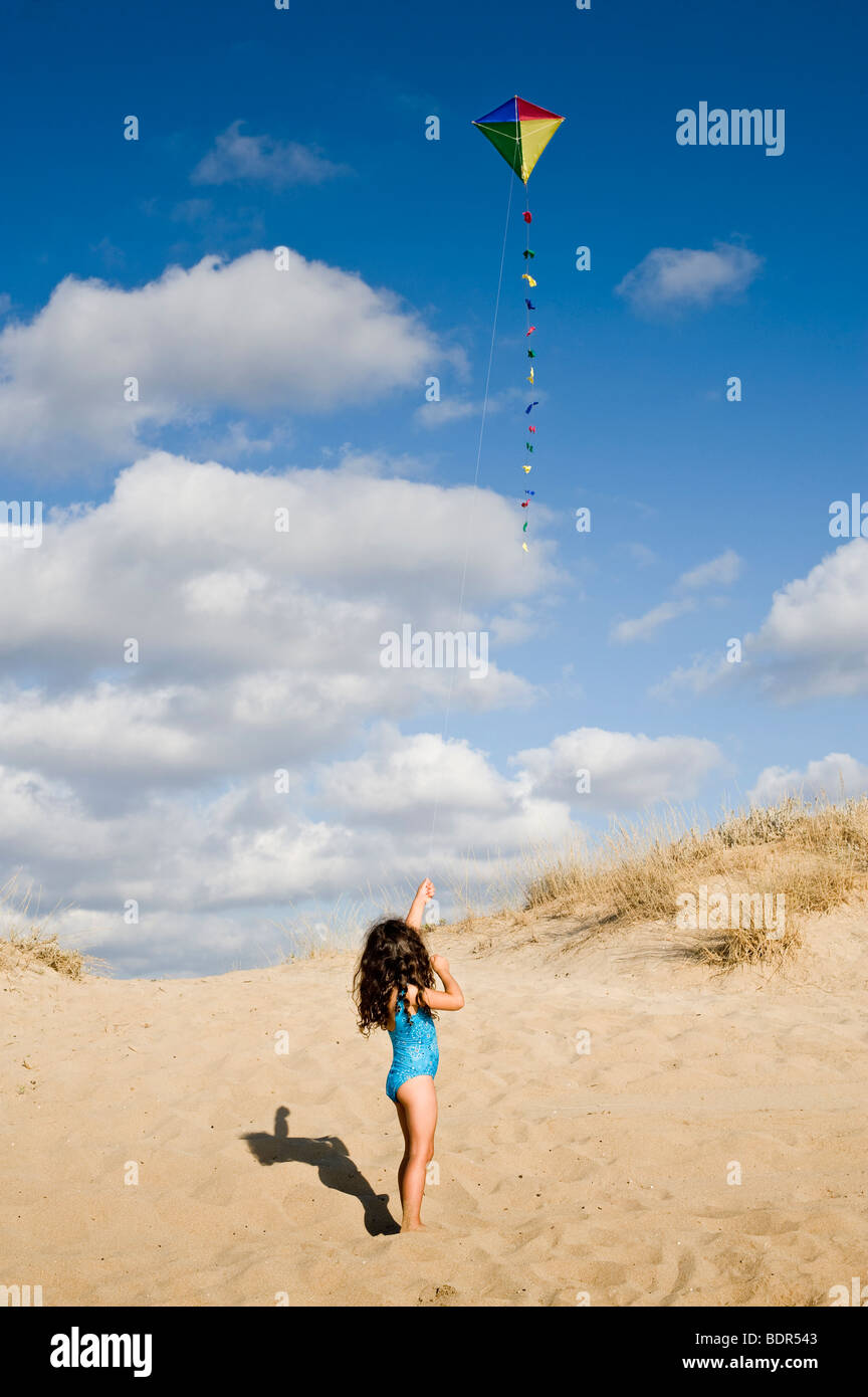 Mädchen am Strand mit einem bunten Drachen spielen Stockfoto