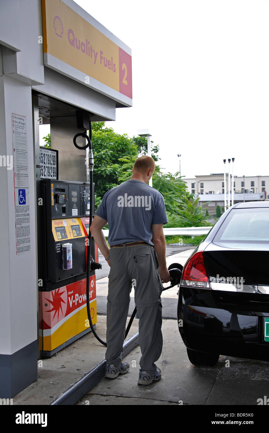 Mann an Shell-Tankstelle Auto mit Benzin füllen Stockfoto