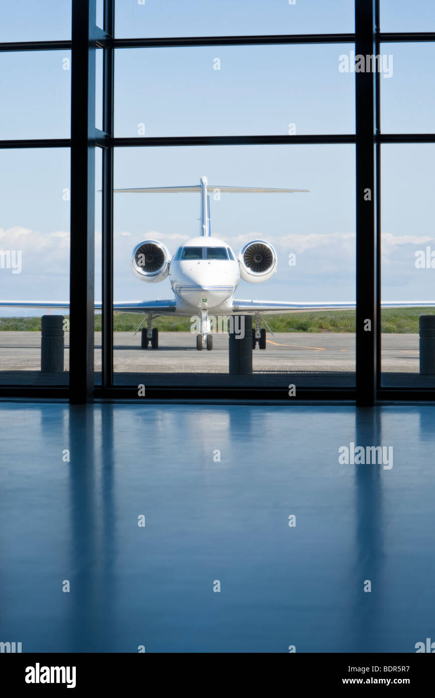 Ein kleiner Zwilling engined corporate Privatjet wartet draußen ein Flughafenterminal. Stockfoto