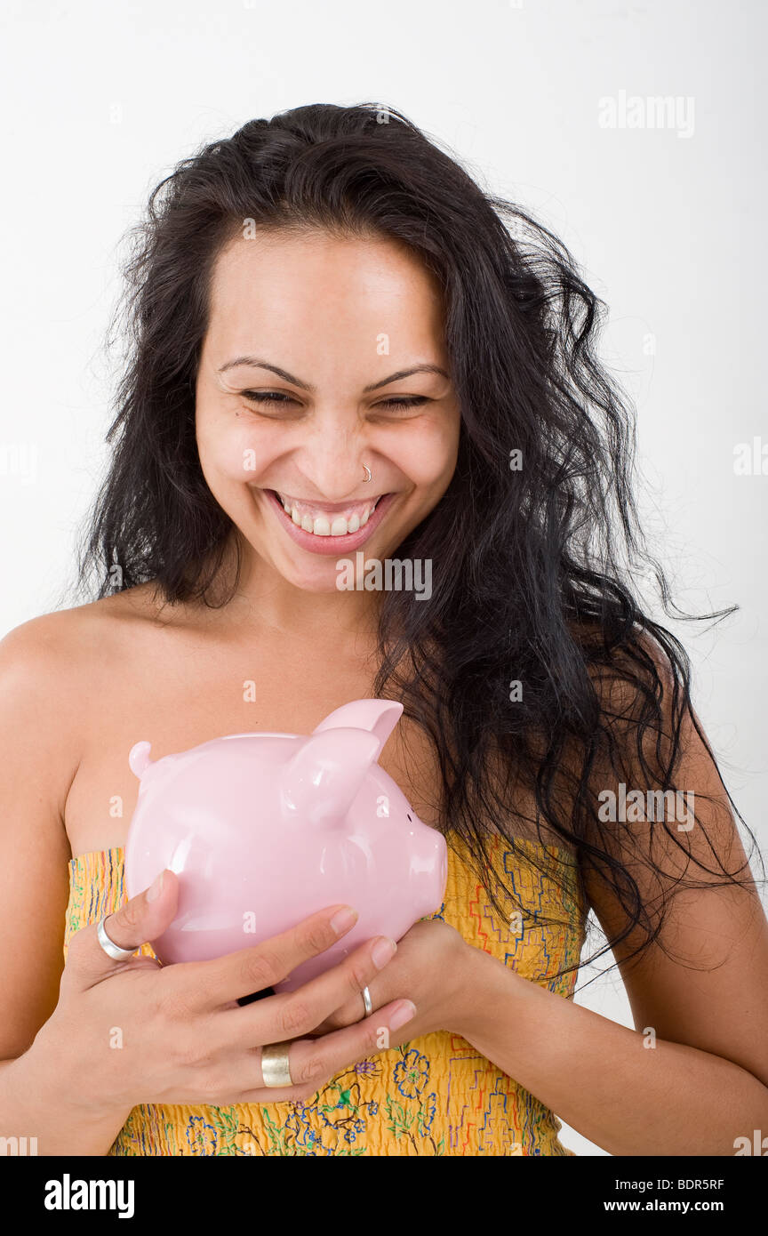 Hispanic Frau hält ein Sparschwein Stockfoto