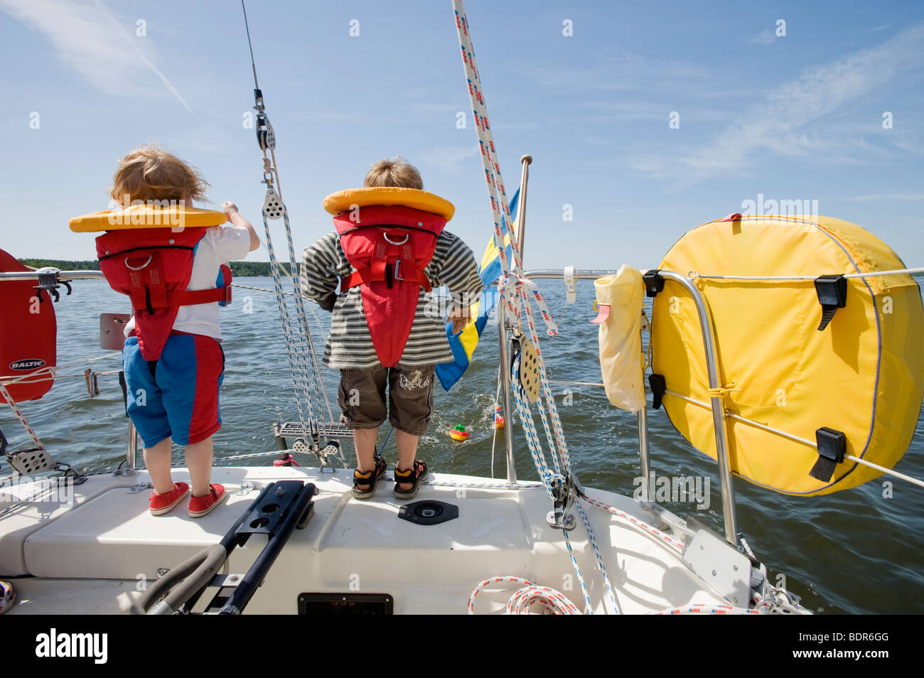 Ein Mädchen und ein Junge steht auf einem Segelboot Schweden. Stockfoto