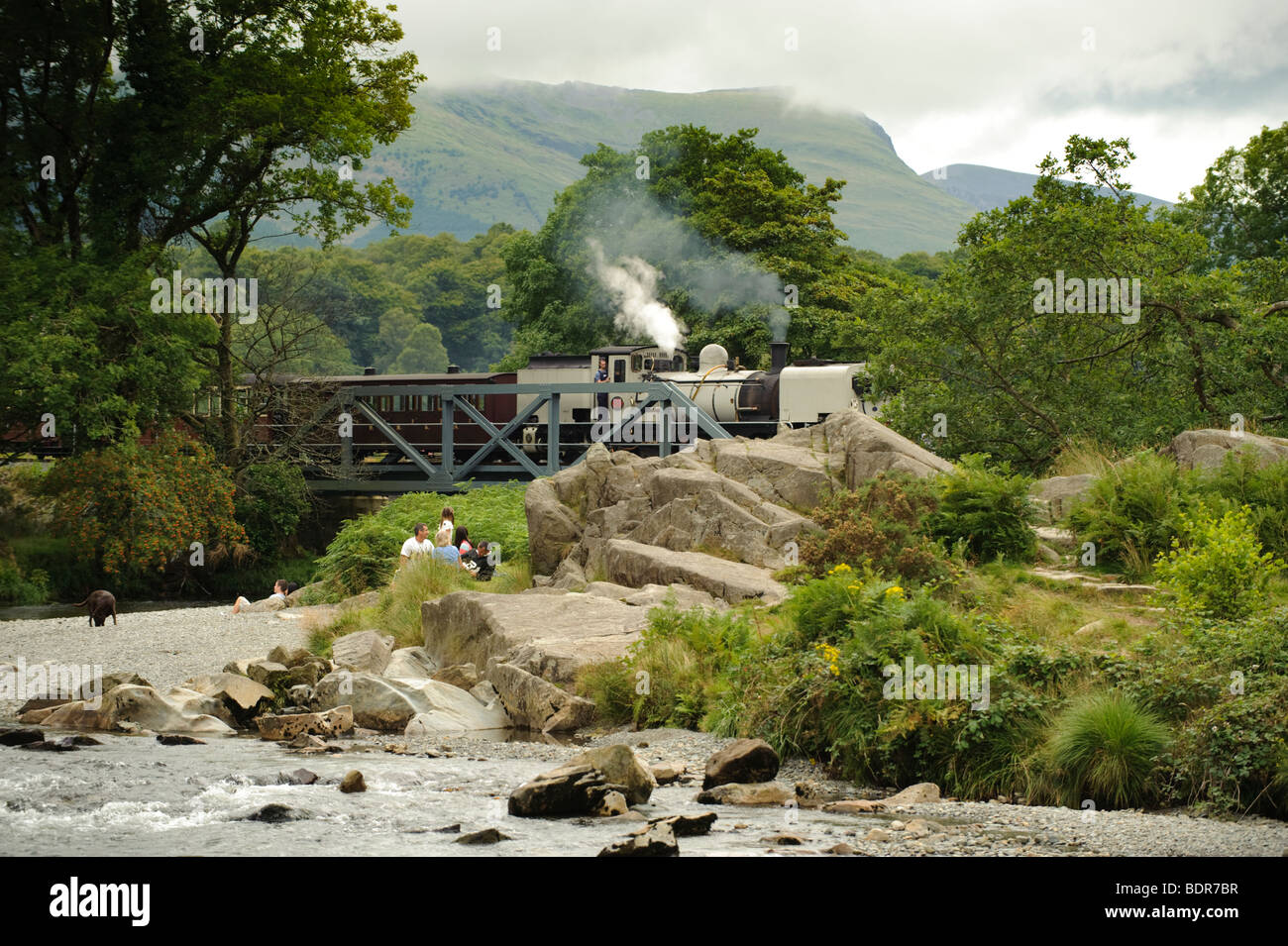 Schmale Lehre Dampfzug auf der Welsh Highland Railway, die Überquerung des Flusses Glaslyn in der Nähe von Beddgelert, Gwynedd Nord wales UK Stockfoto